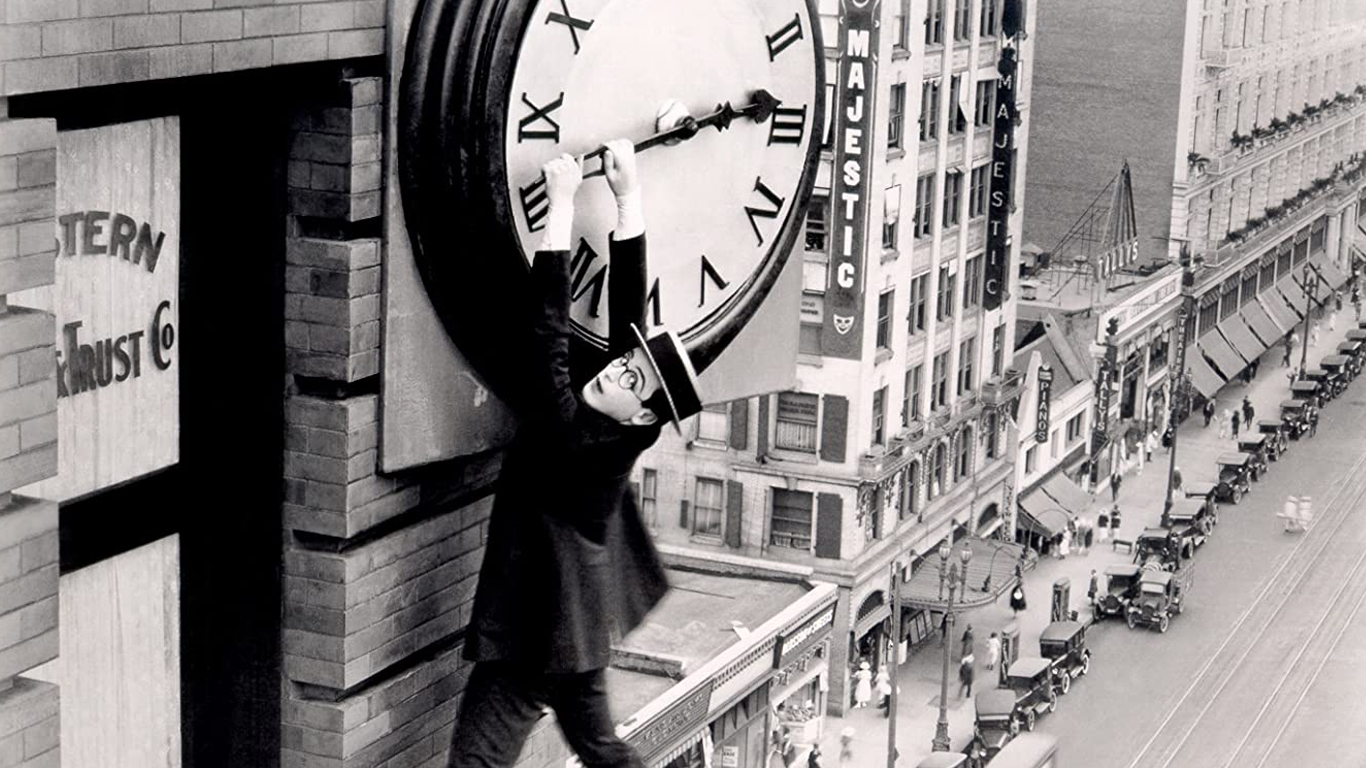 Harold Lloyd hanging desperately from the hands of a skyscraper clock during Safety Last! (1923) / Hal Roach Studios