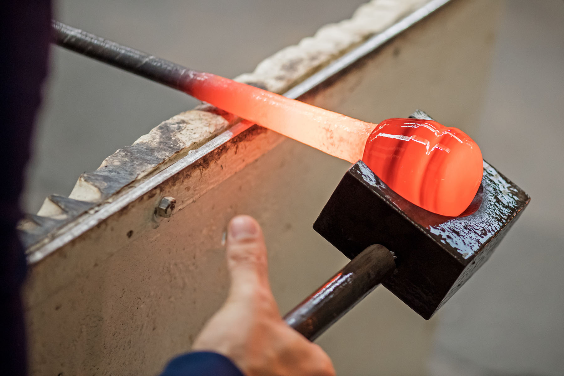 Making the Millefiori using patterns assembled from hot threads pulled from the molten material drawn from the mouth of the pots in the furnace. 
