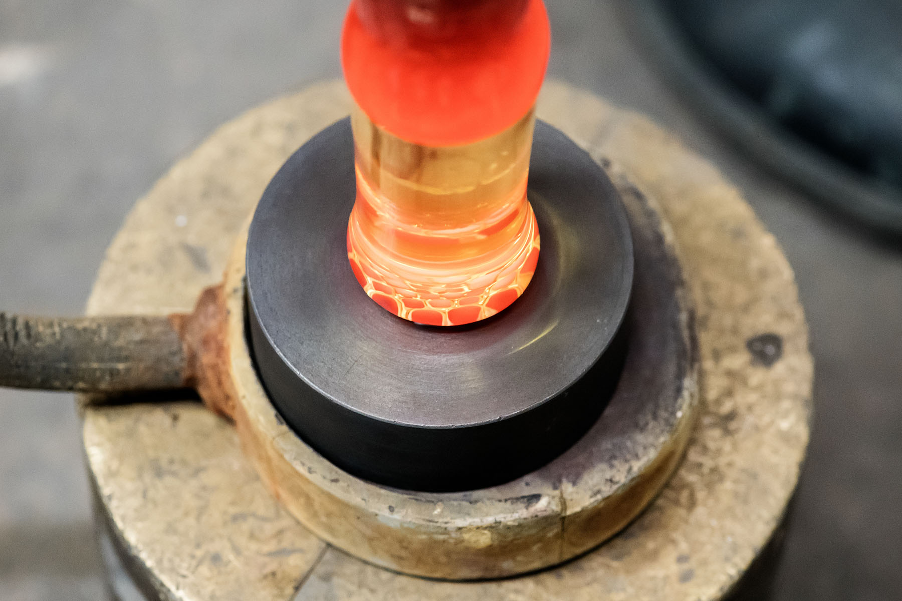Making the Millefiori using patterns assembled from hot threads pulled from the molten material drawn from the mouth of the pots in the furnace. 