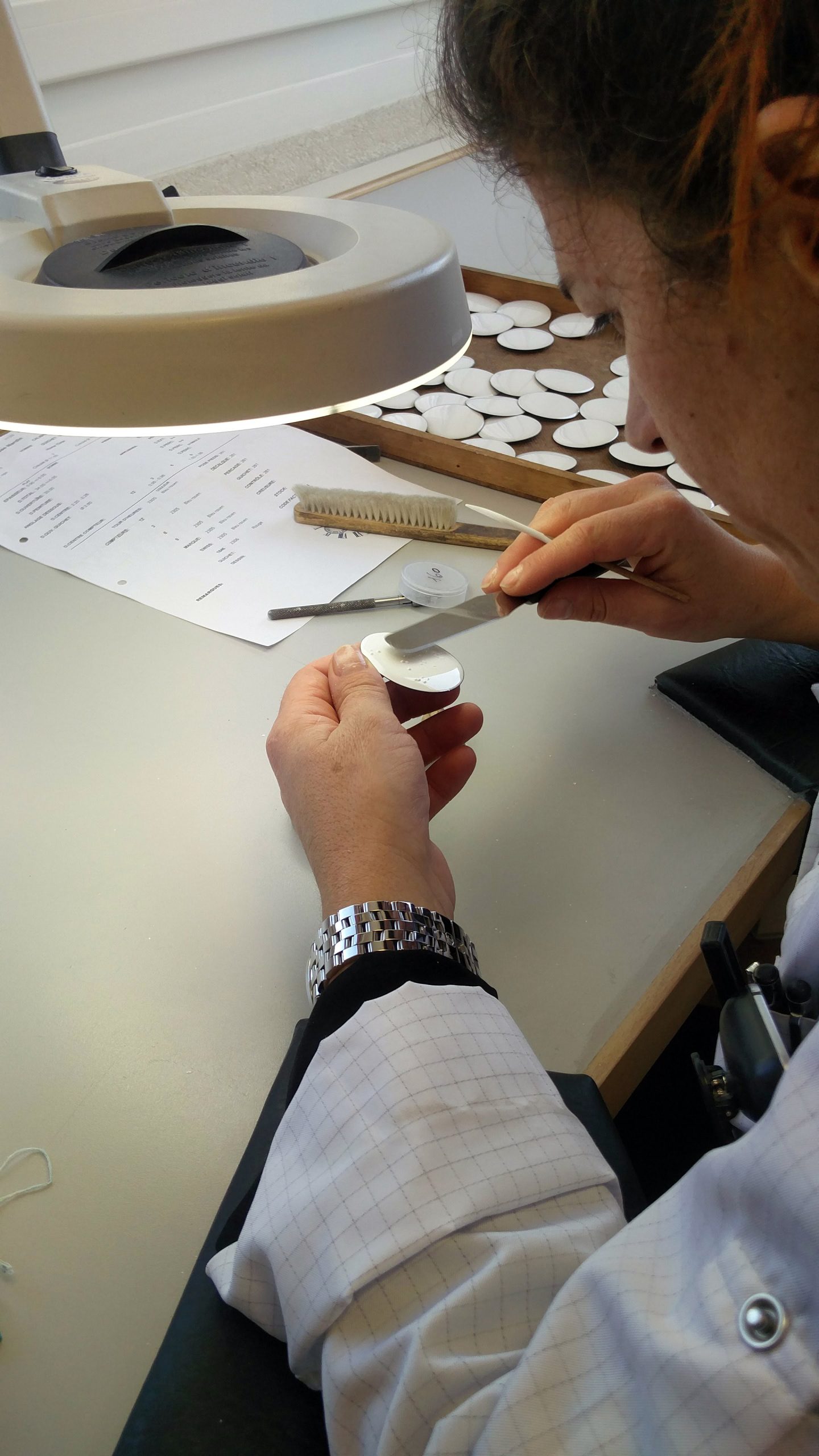 Smoothening the surface of the dial with enamel to maintain a levelled surface.