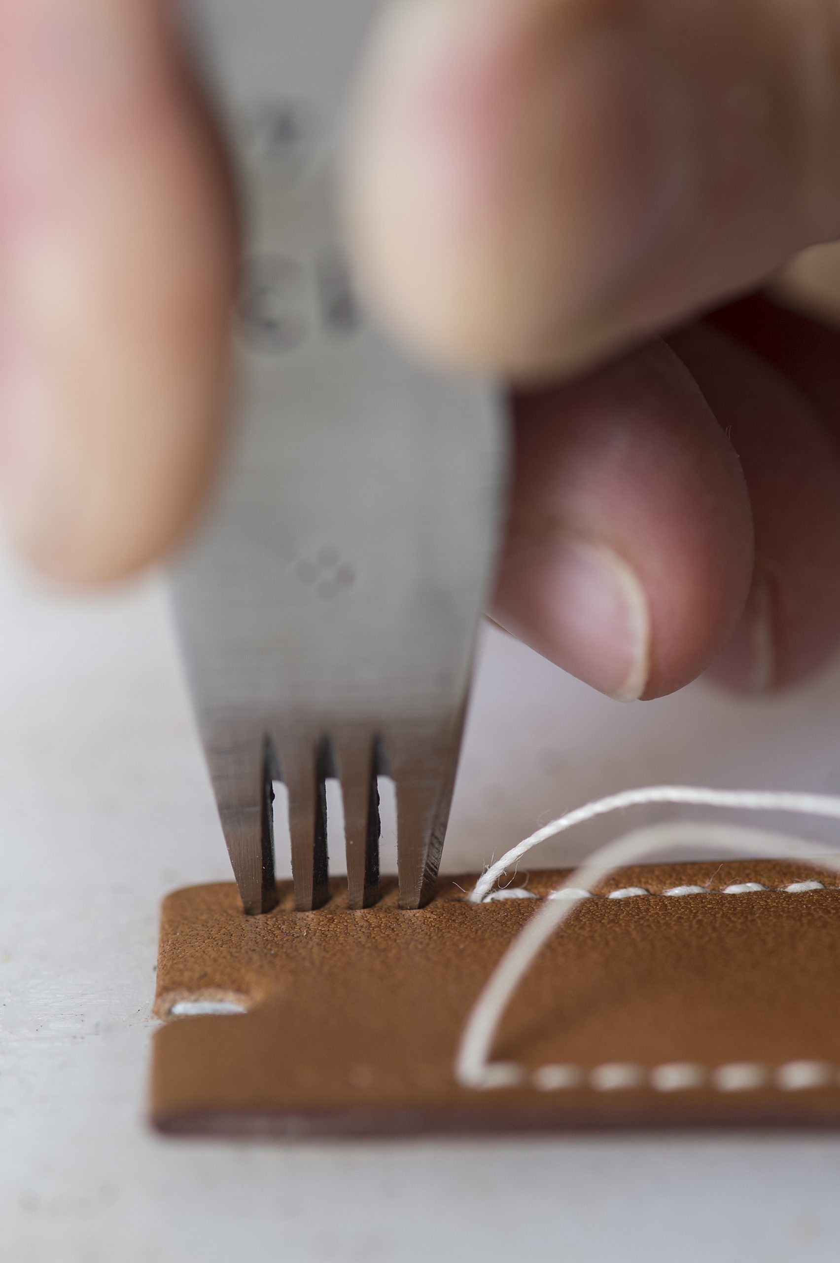 A forklike tool with many tines punches holes for the saddler’s stitches. Threads running in opposite directions join the leather upper and lower skins to the textile lining between them.