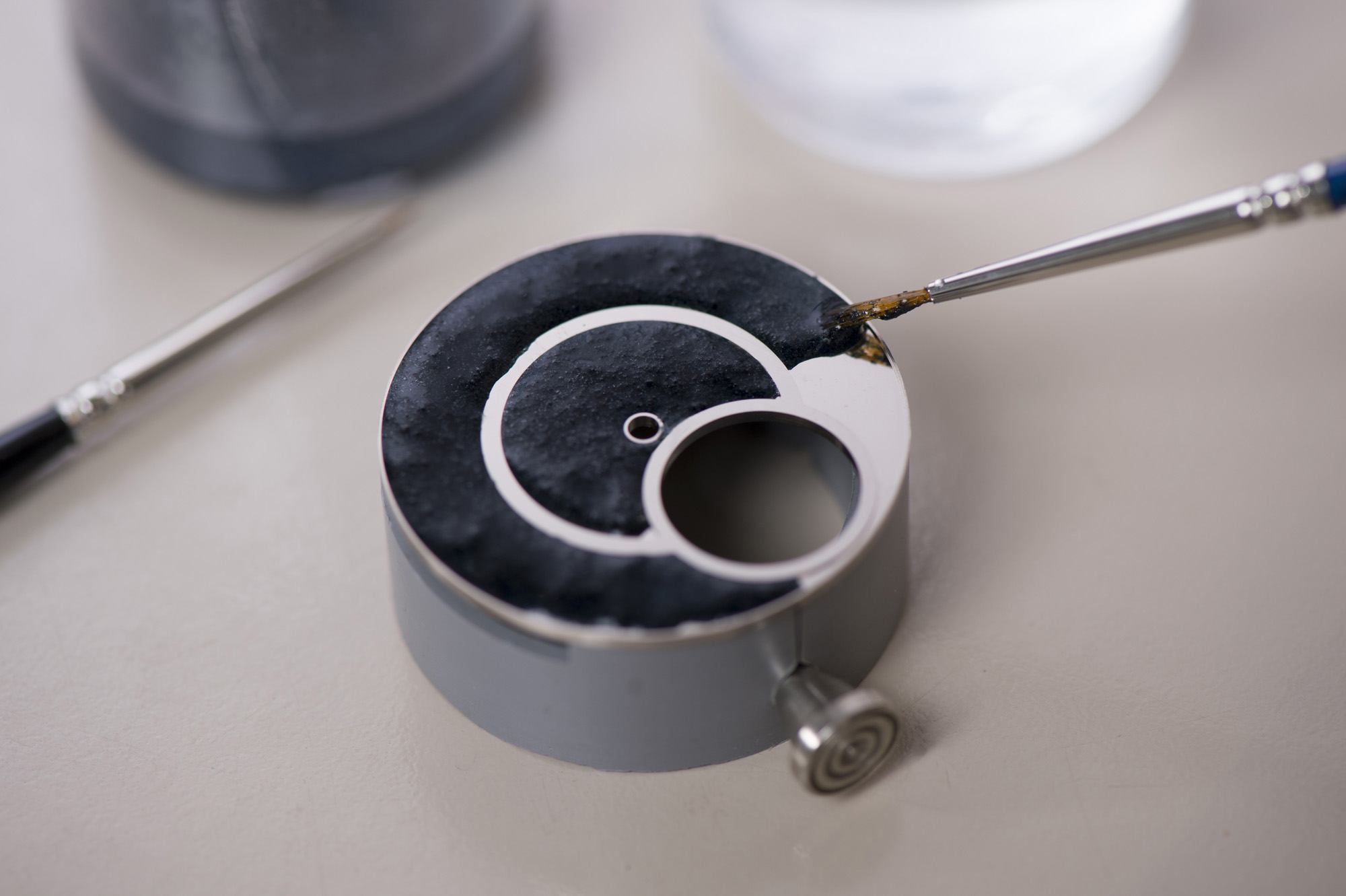 The artisans work with a gold case featuring a 0.4 mm recess coated with three layers of white enamel. The motif is then designed using enamel fragments coloured by metal oxides that are crushed to powder and mixed with oil.