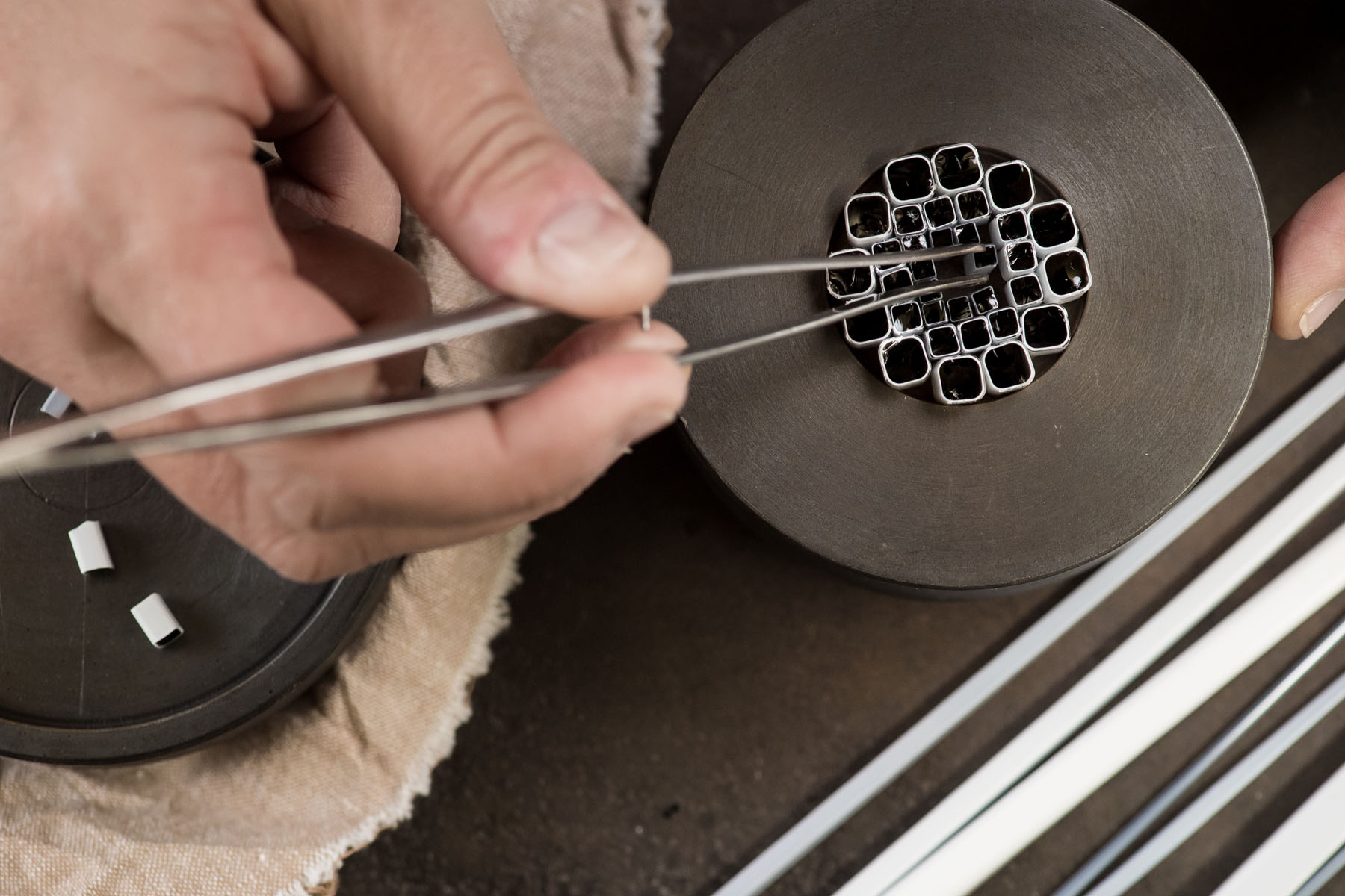 Making the Millefiori using patterns assembled from hot threads pulled from the molten material drawn from the mouth of the pots in the furnace. 