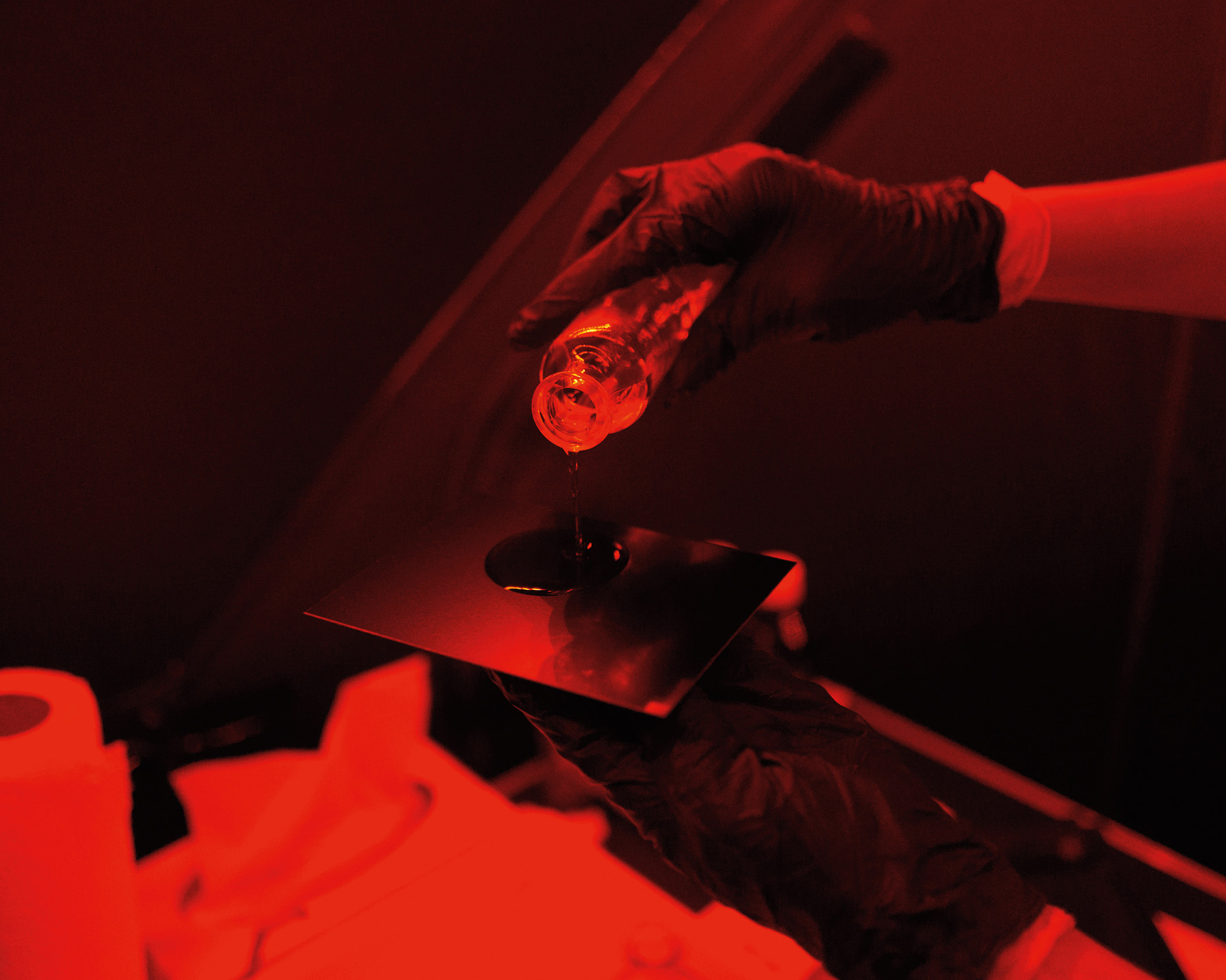 In the darkroom, the coated plate is dipped into a dish containing silver nitrate solution. In this phase, the iodine salts are chemically replaced by light-sensitive silver iodide and silver bromide particles that are evenly distributed in the collodion coating. The wet plate prepared in this way is placed in a light-tight plate holder and slid into the camera.