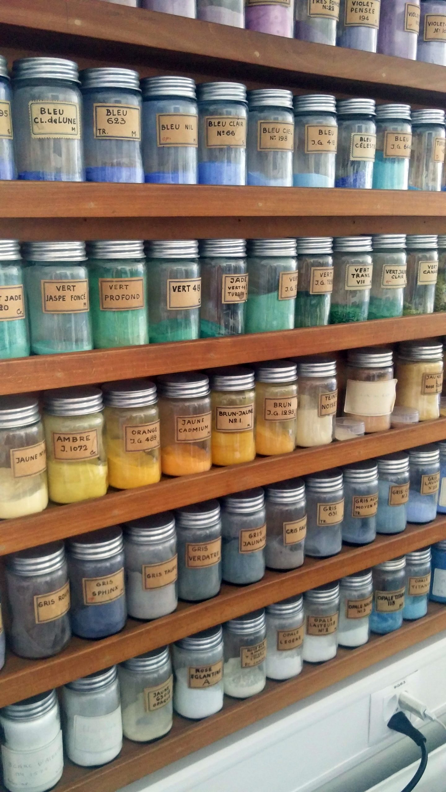 Jars of coloured enamel powder on display