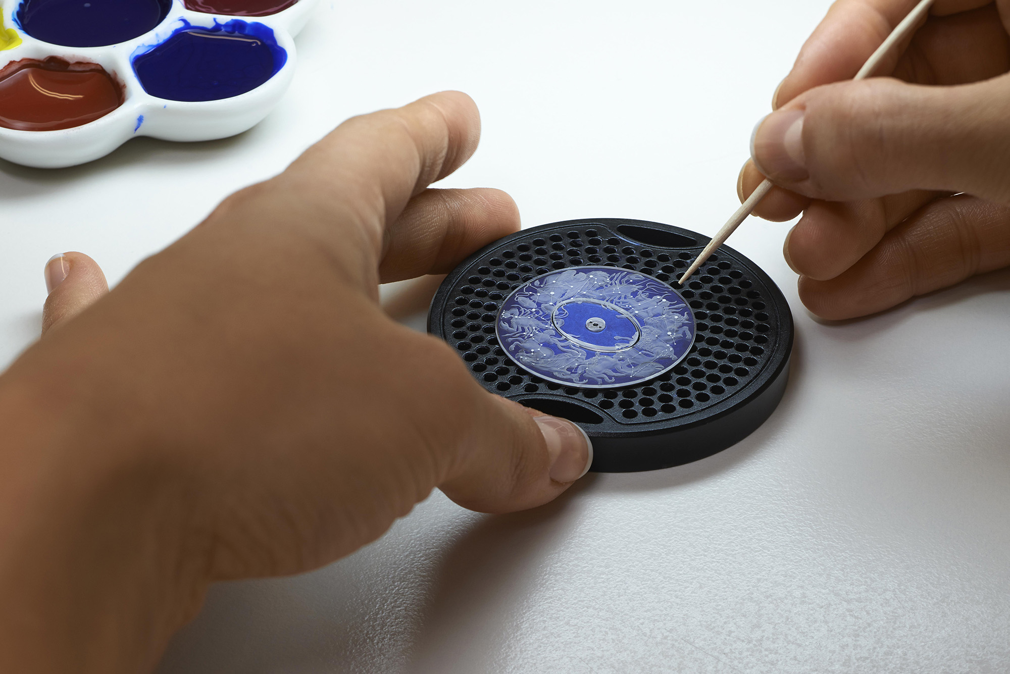 A hand-painted midnight blue underdial is overlaid with a transparent sapphire crystal engraved on its back, with the symbols sculpted on it using a laser technique. After this, the engraver over them by hand to accentuate the raised motifs and sapphire.