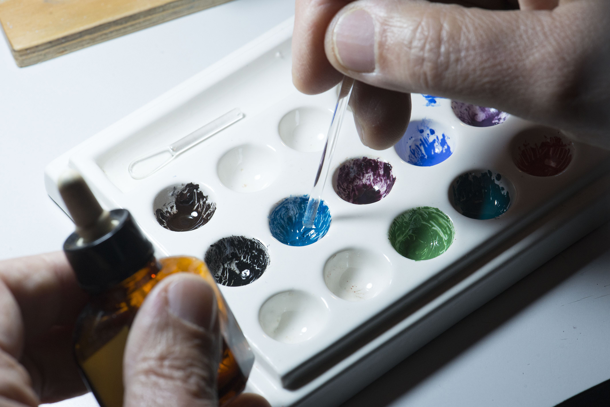 The colours are prepped on a palette, for the artist to bring the design under the brush.